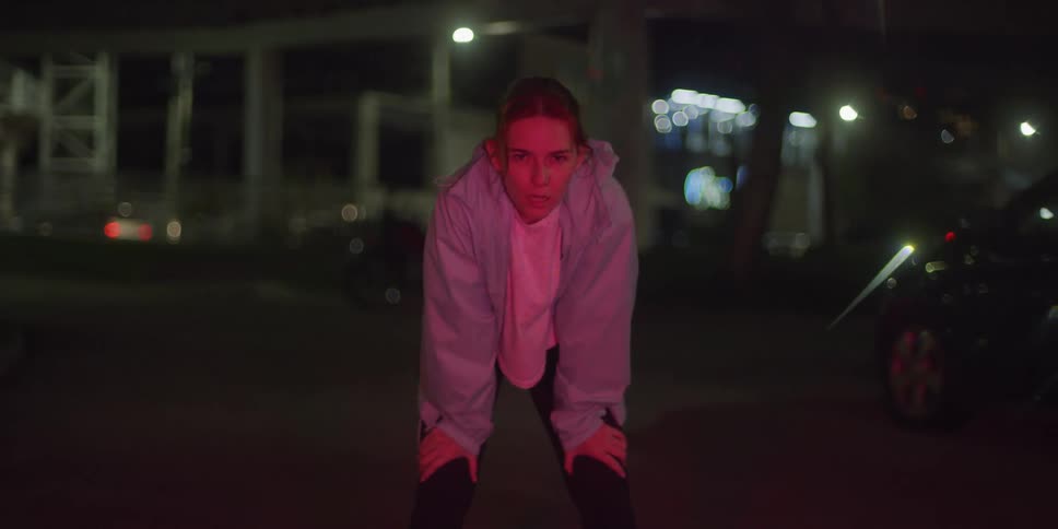 Woman with hands on knees taking deep breaths