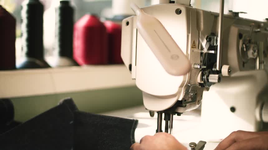 Pair of hands working with fabric on a sewing machine