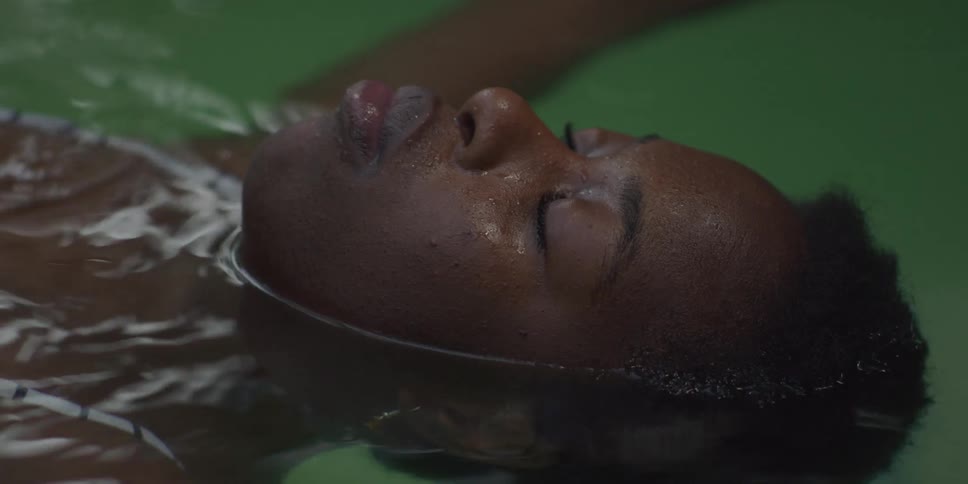 A black woman moves her arms while floating in a swimming pool