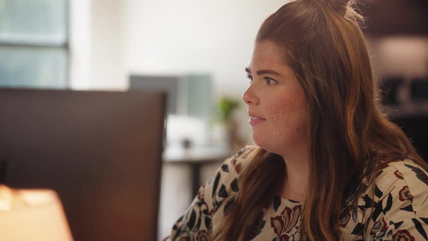 A woman is looking at a compute rand smiling
