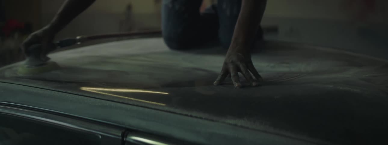 Mans hand polishing the top of a vehicle