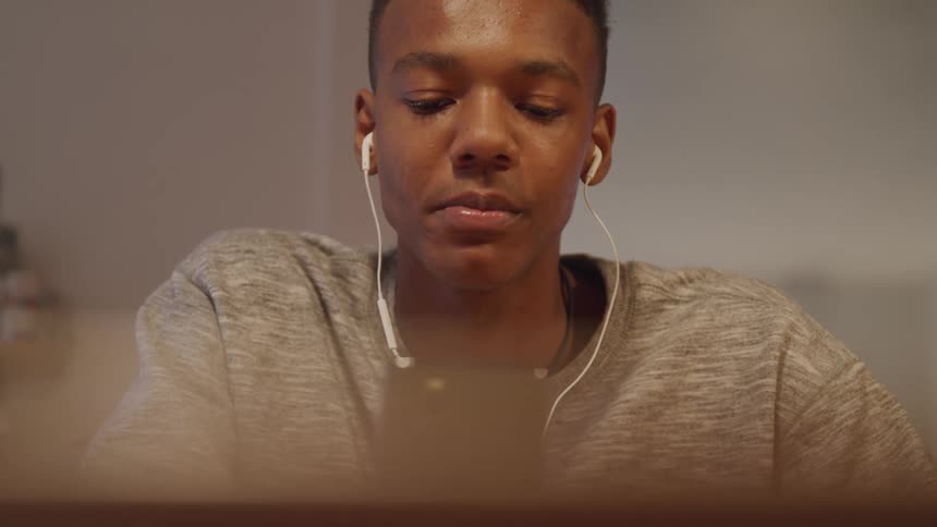 A guy wearing headphones and chewing