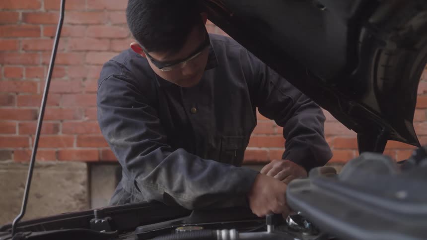 A mechanic works on a car