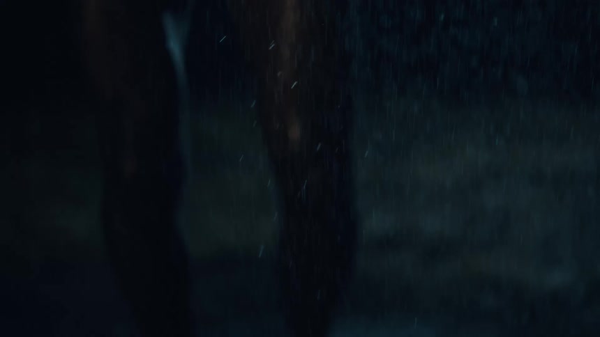 Flashes of light illuminate a person being splashed with water at night
