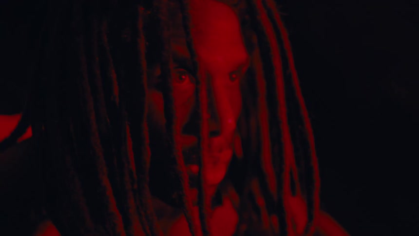 Portrait of a man with dreadlocks and a red light on his face