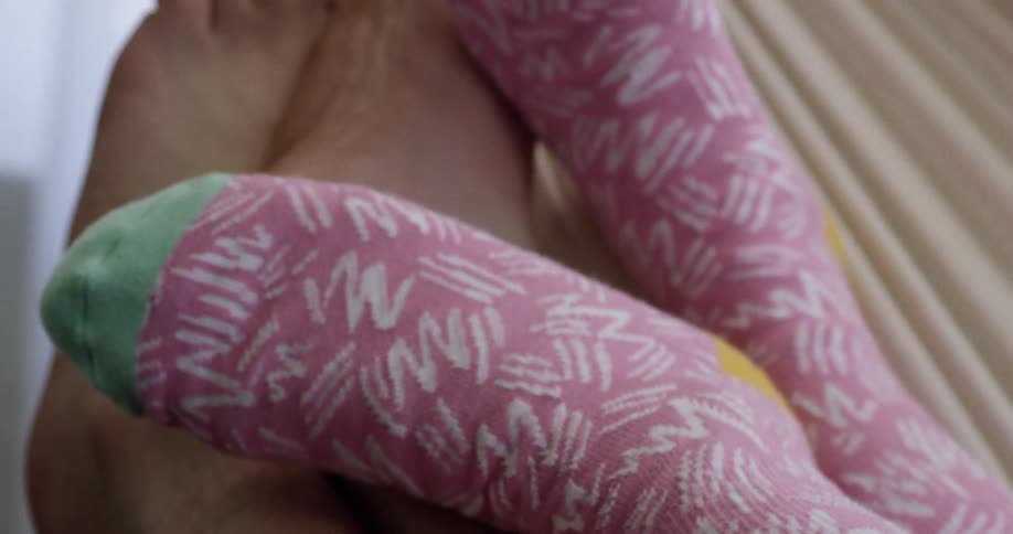 Feet of two people lying together in a hammock