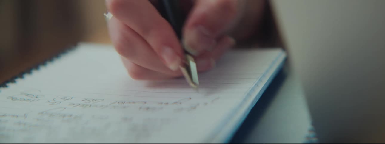 A woman is writing in her notebook