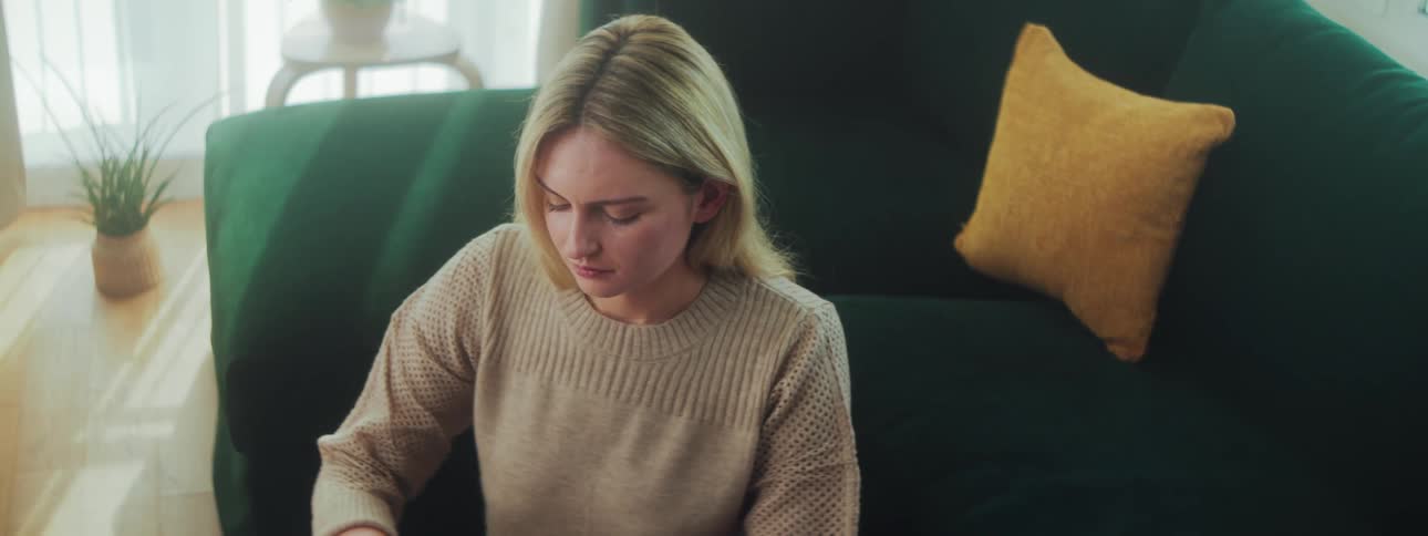 Concentrated blonde woman typing on a laptop