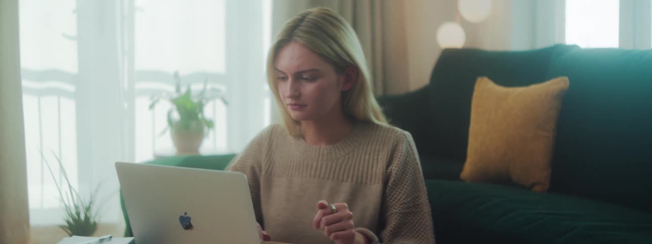 A woman in a room working on her laptop