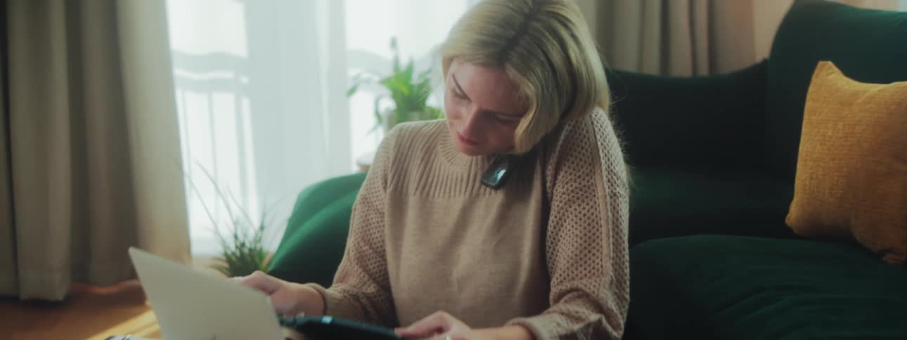 While talking on the phone a woman picks up a notebook and reads it