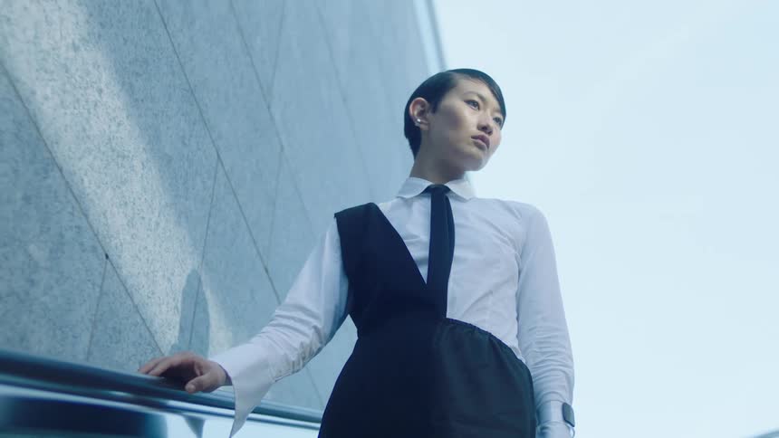 Woman in formal wear going down an escalator