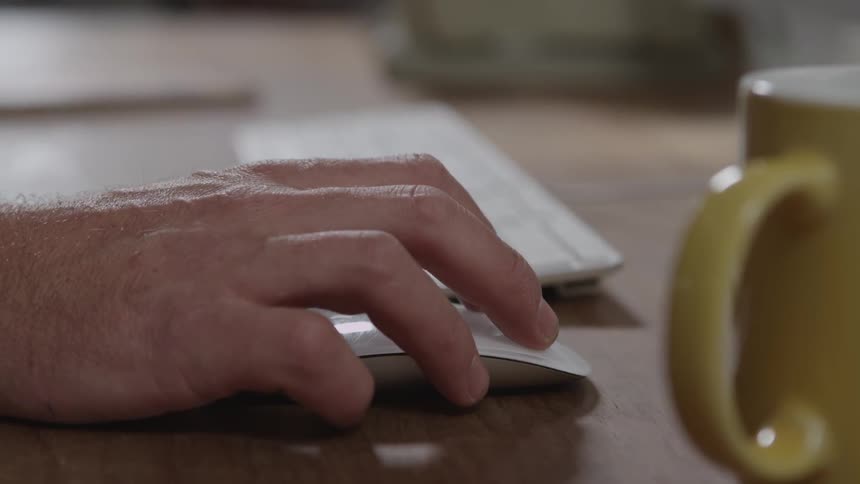 A person using a mouse on a desk