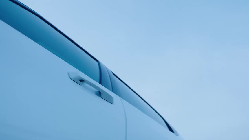 A four door car is parked outdoors on a clear sky day