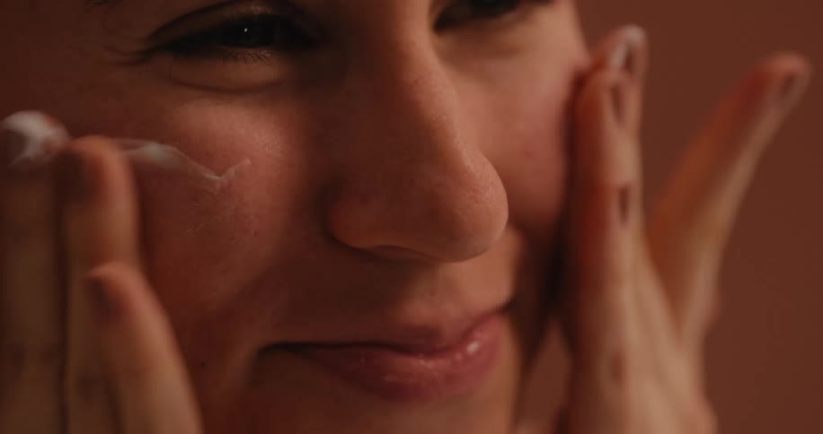 A woman is using soap to clean her face