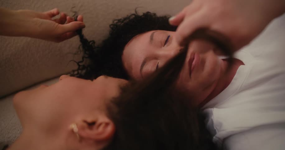 Two women gently stroking each others hair