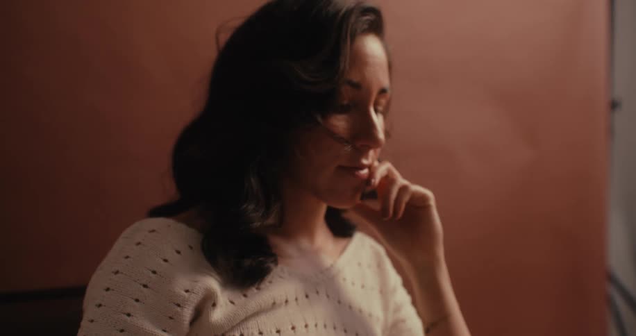 Woman with her hand on her face and a thoughtful facial expression