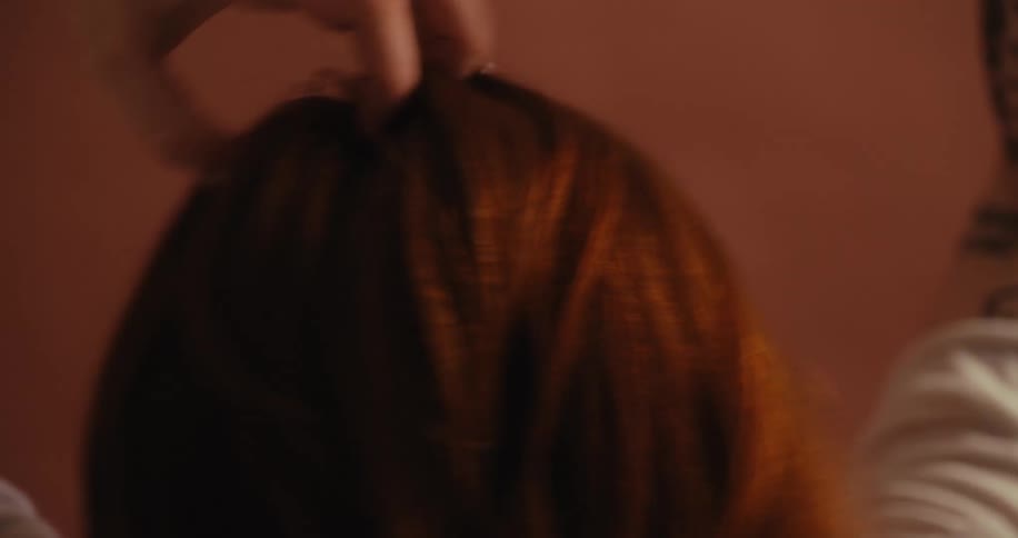 A woman is scratching her head and whipping her hair around