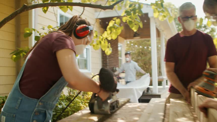 Women are sanding wood under the tree