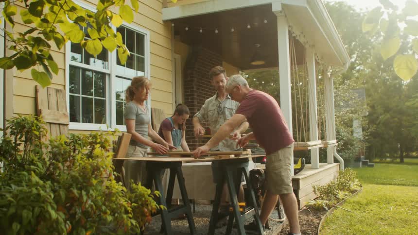 Four people around a table working on a wood project