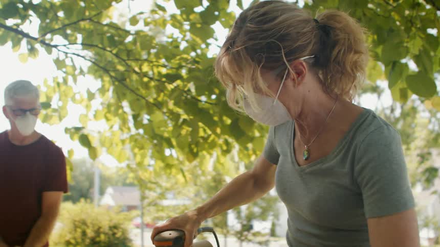 Family sanding a wooden plank with a power sander outdoors as part of a home renovation project
