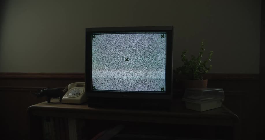 The television is on in the dark room