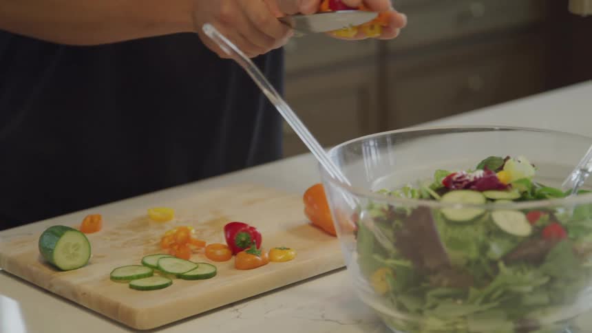 A woman is making a salad