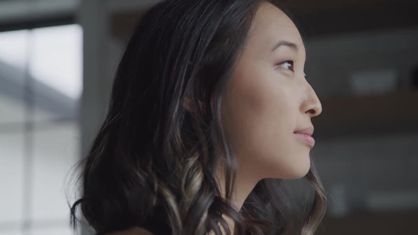 Side portrait of young woman looking forward with happy expression