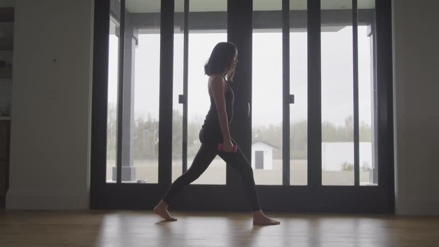 A woman is exercising with small weights