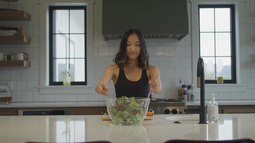 Woman in the kitchen preparing a salad