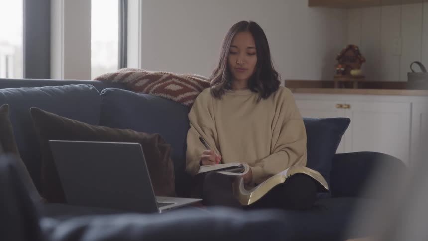 A woman is writing notes in her notebook