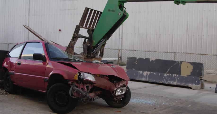 A piece of heavy machinery crushes a car