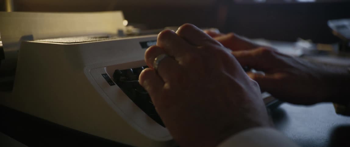 A person is typing on a type writer inside a quiet room