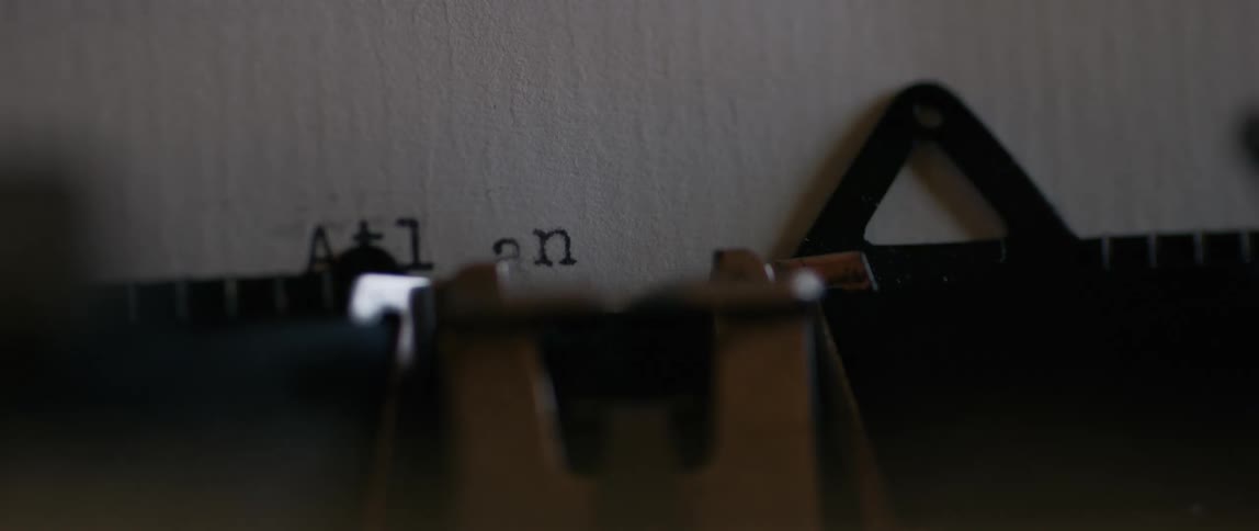 Close up of an old school manual typewriter typing atl anta on a white sheet of paper