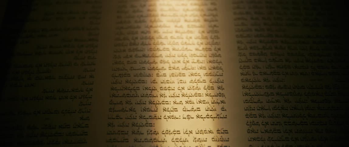 A large scroll with text in a foreign language unrolls from right to left