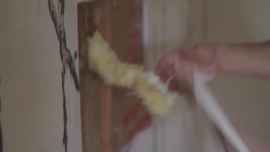 A man tears parts of a wall off