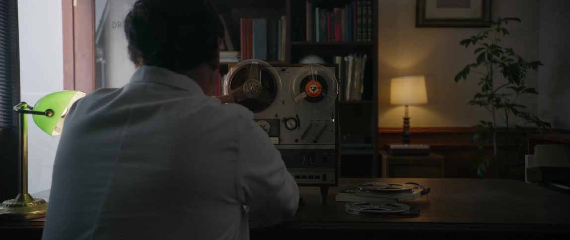 A man is using an old tape recorder