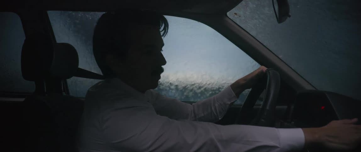 A man is carefully driving through a thunderstorm