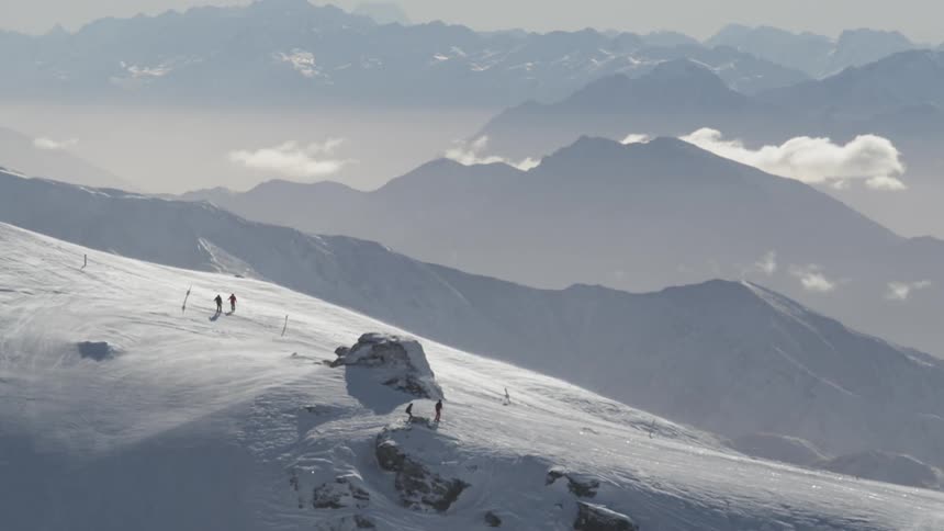 Skiers descend a snowy mountain