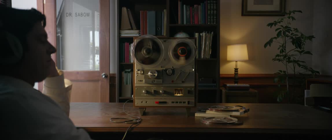 A man is listening to an old tape recorder