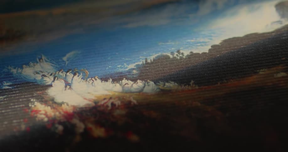 Sunlight shines onto a picture covering a piece of textile lying in a dimly lit room