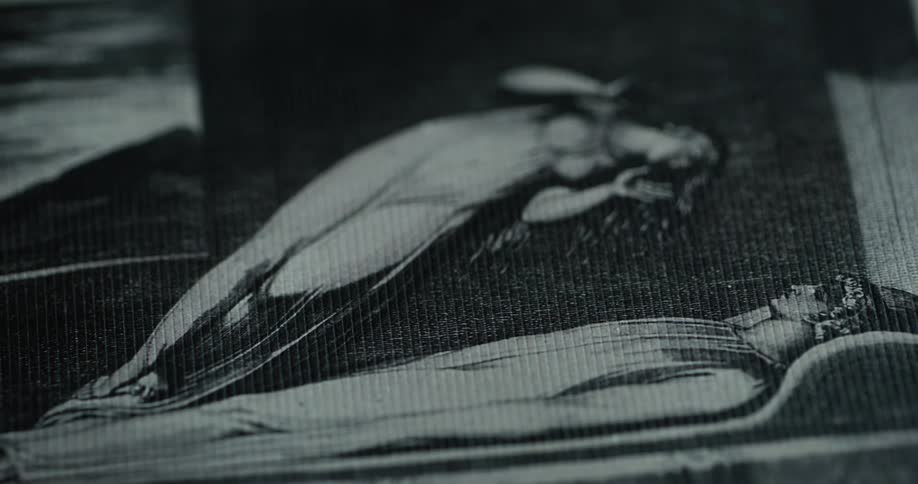 A black and white painting is in a dark area
