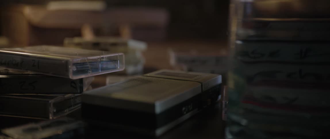 Several video tapes are laid out on a table
