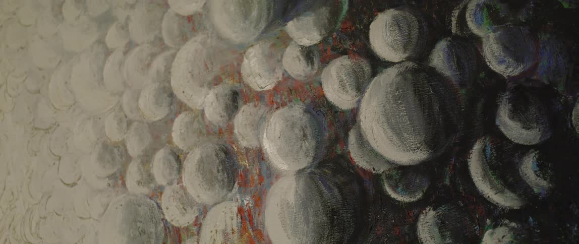 Closeup of artwork showing red accenting rounded rocks