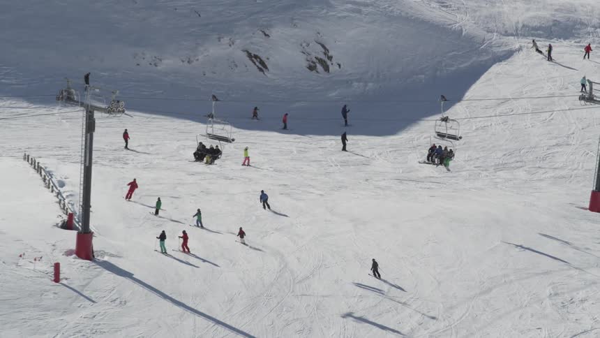 Skiers descend a snowy mountain