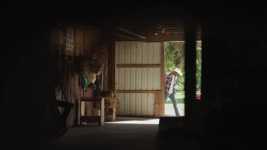Man closing the door of a stable