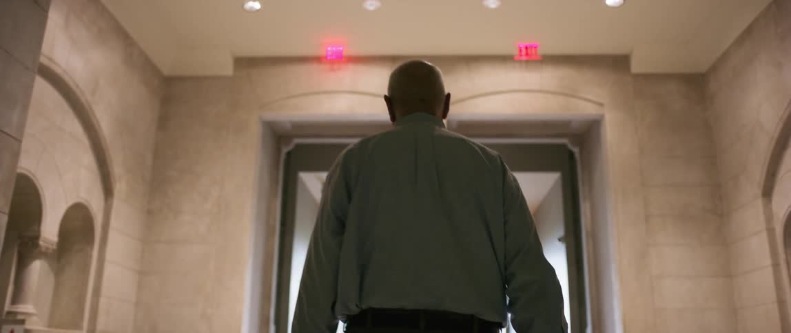 A man walks though a brick hallway