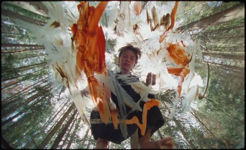 Woman artist painting in a clear acrylic in a forest
