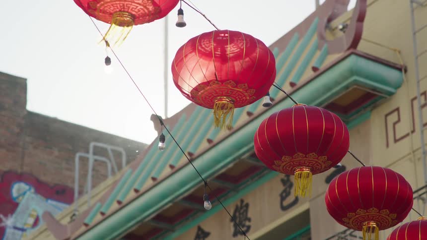 Paper lanterns hang between the buildings