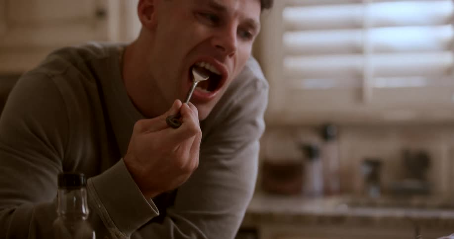 Man is eating pancakes for breakfast in his home