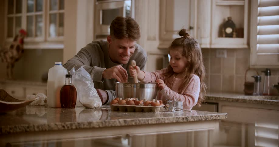 Father and daughter in the kitchen having fun cooking